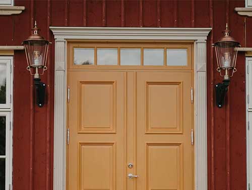 Klassisk belysning med lyktor på vardera sida av dubbeldörr